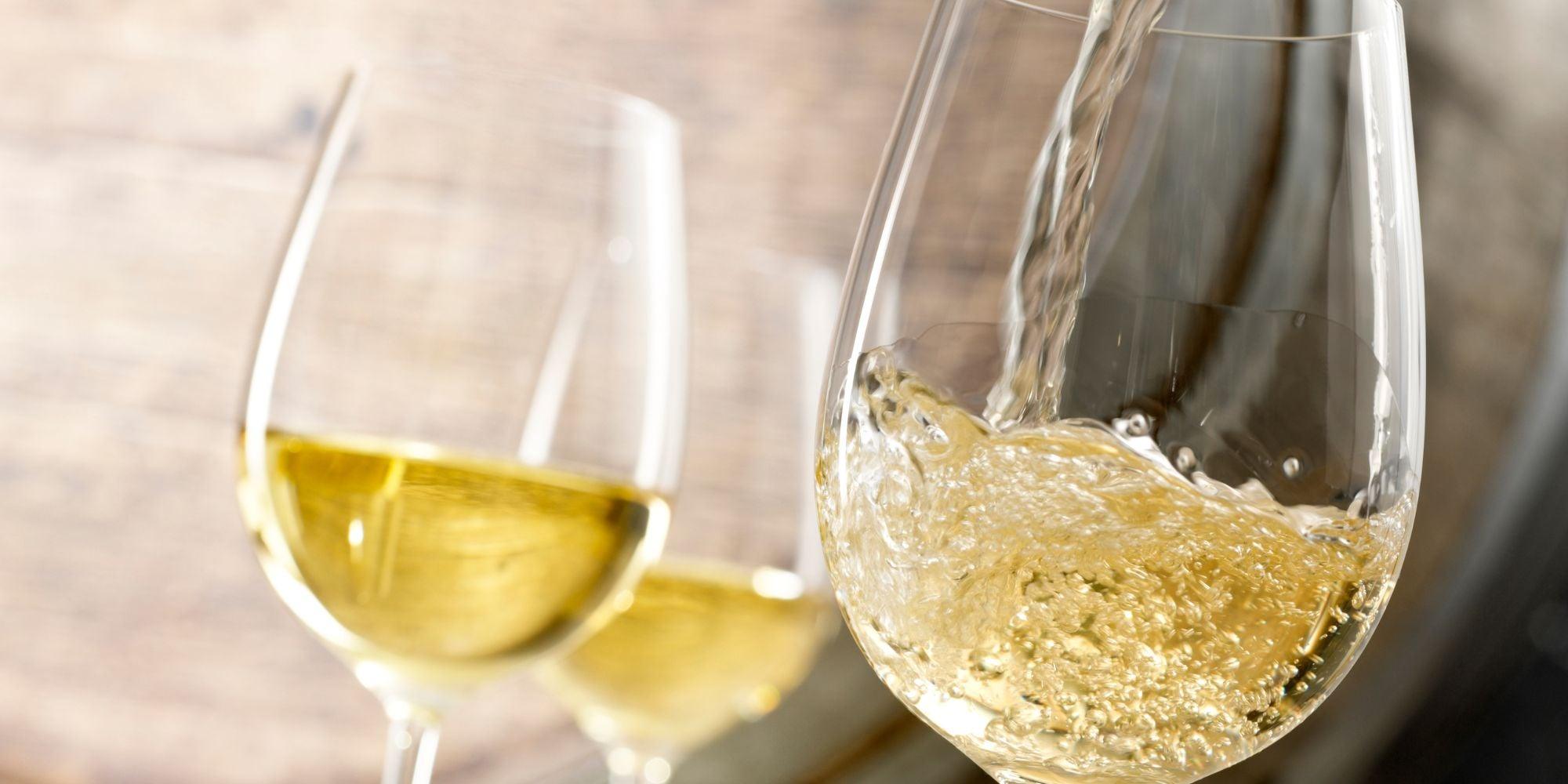 Weißwein in ein Glas einschänken